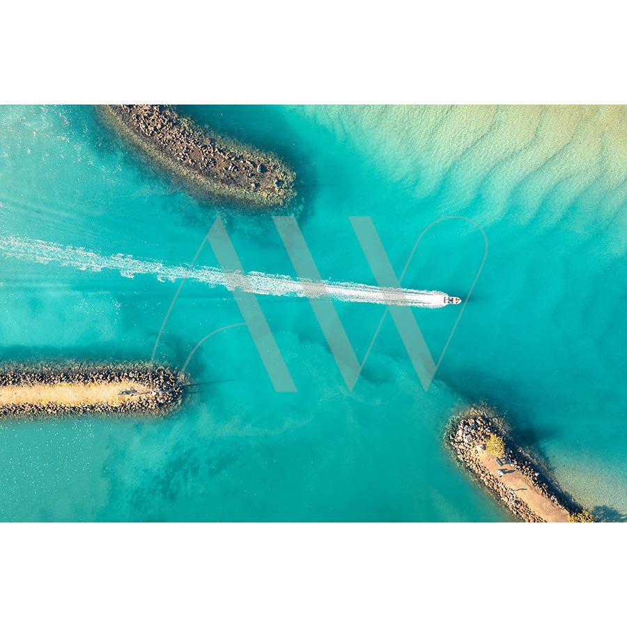 Brunswick Heads Drone Image 0215 by AWP Image Library captures a speedboats white wake against turquoise water, weaving between rocky islands with curved trails. Sunlit shallow areas are visible near the top.