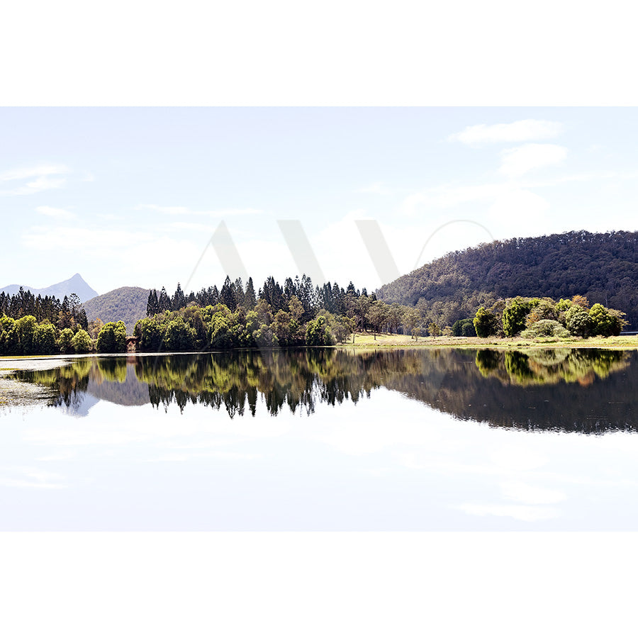 Doon Doon Creek Image 6184 by AWP Image Library captures a tranquil lake mirroring verdant trees and wooded hills beneath a clear blue sky.