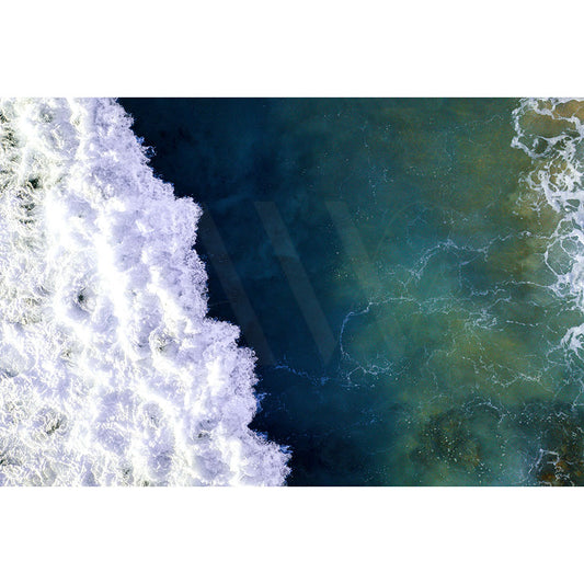 Drone image Mudjimba Beach Drone Image 0018 by AWP Image Library captures an aerial view of ocean waves crashing onto Mudjimba Beach in the early morning, showcasing a stark contrast between frothy white surf on the left and deep green-blue water on the right.