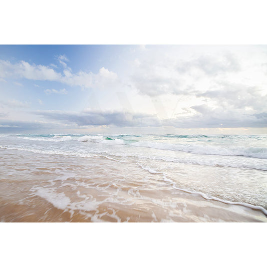 Experience tranquility with Peregian Beach Image 5830 from AWP Image Library, capturing serene waves on a sandy shore under a cloudy sky. The horizon beautifully melds into soft blue and white clouds, offering an expansive ocean view.