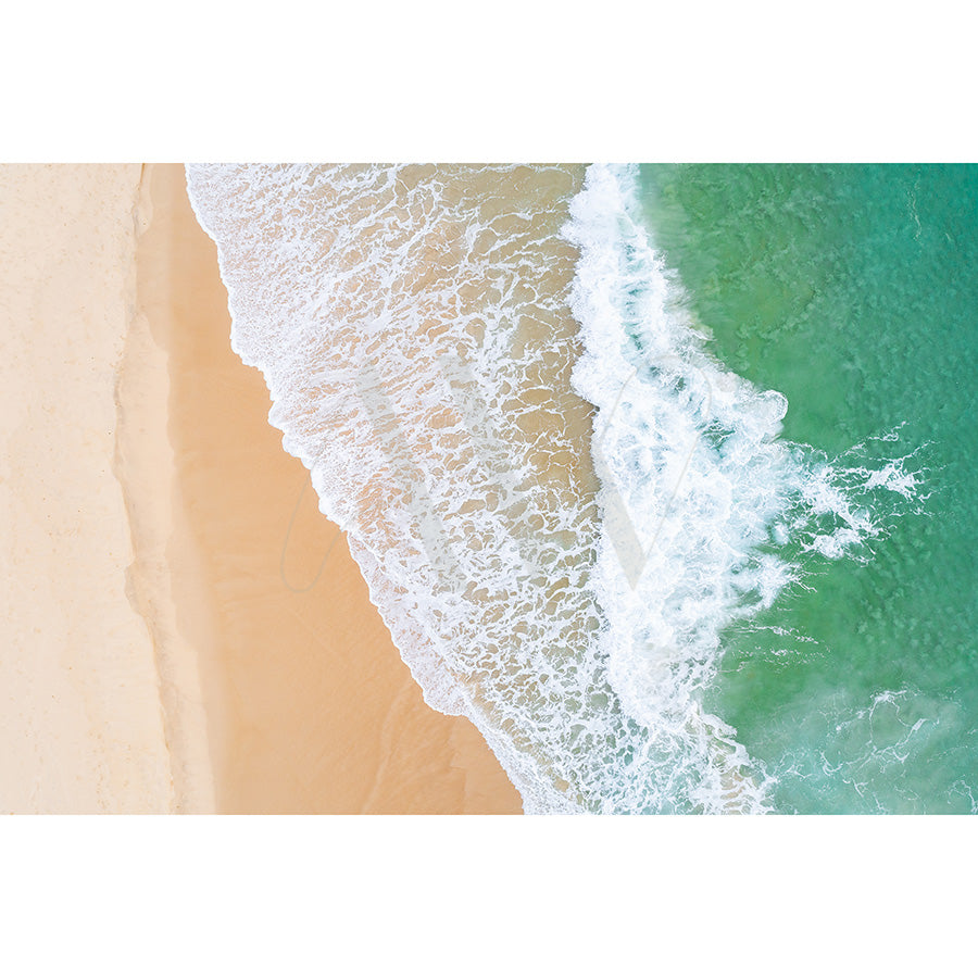 Peregian Beach Drone Image 0106 by AWP Image Library captures an aerial view of a serene, empty beach. Waves crash onto the sand, and the water shifts from deep green to turquoise as it meets the shore with no visible people or objects.